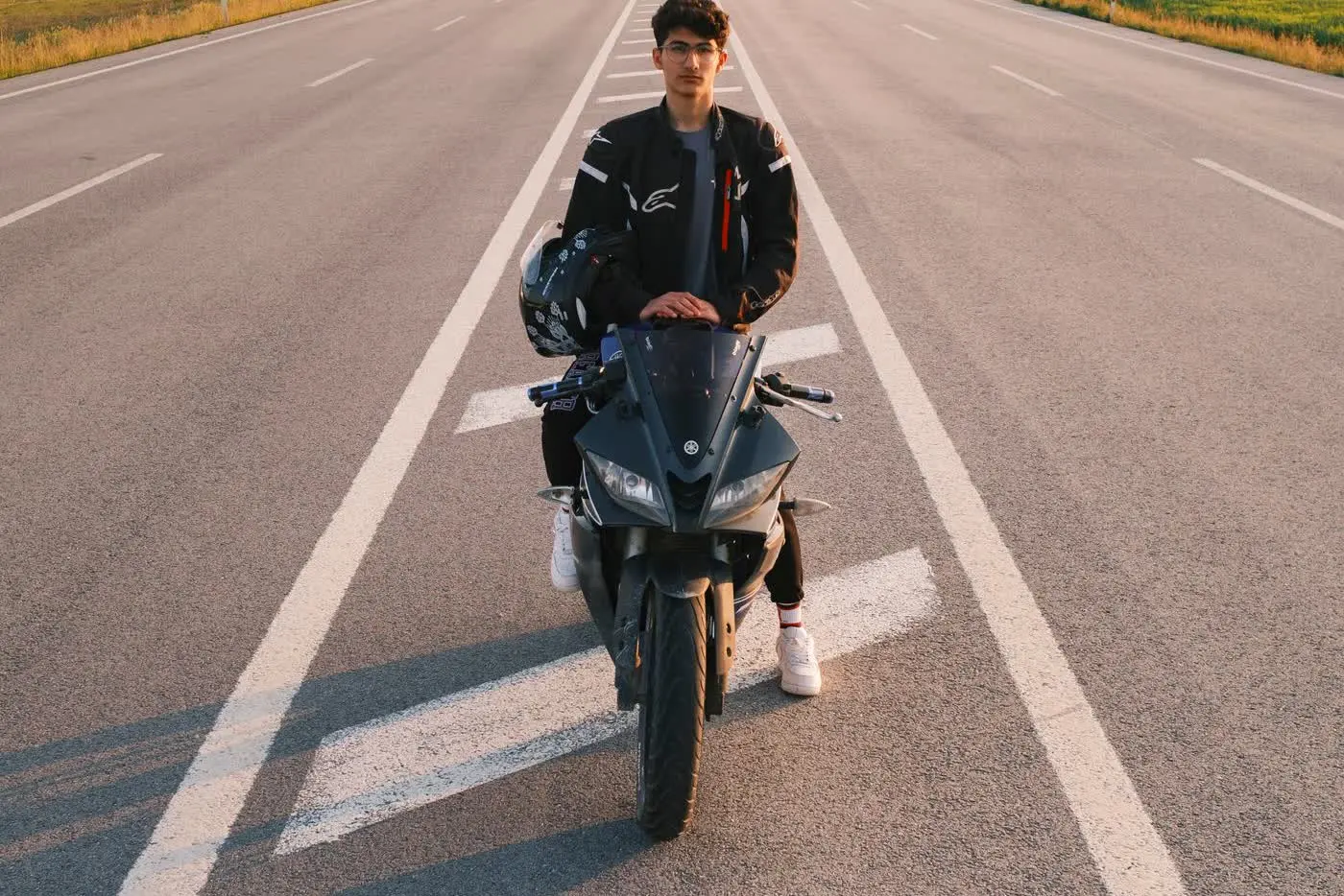 Motoros védőfelszerelésben, motorkerékpárral egy nyílt úton